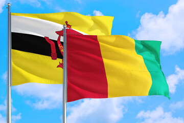 Guinea Bissau and Brunei national flag waving in the windy deep blue sky. Diplomacy and international relations concept.