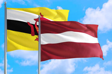 Latvia and Brunei national flag waving in the windy deep blue sky. Diplomacy and international relations concept.