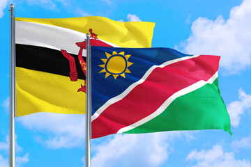 Namibia and Brunei national flag waving in the windy deep blue sky. Diplomacy and international relations concept.