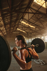 Woman doing squats workout in old warehouse