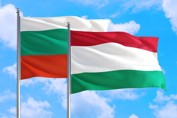 Hungary and Bulgaria national flag waving in the windy deep blue sky. Diplomacy and international relations concept.