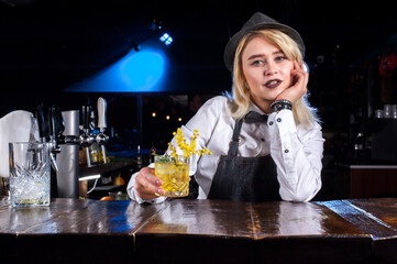 Charming girl bartending demonstrates his skills over the counter  