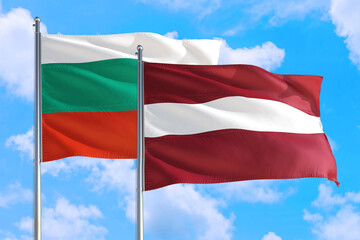 Latvia and Bulgaria national flag waving in the windy deep blue sky. Diplomacy and international relations concept.