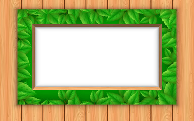 green leaf picture frame on the wooden wall