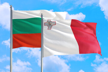 Malta and Bulgaria national flag waving in the windy deep blue sky. Diplomacy and international relations concept.