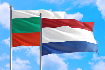 Fototapeta na wymiar Netherlands and Bulgaria national flag waving in the windy deep blue sky. Diplomacy and international relations concept.