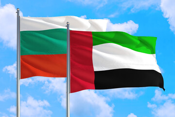 Fototapeta na wymiar United Arab Emirates and Bulgaria national flag waving in the windy deep blue sky. Diplomacy and international relations concept.