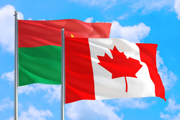 Canada and Burkina Faso national flag waving in the windy deep blue sky. Diplomacy and international relations concept.