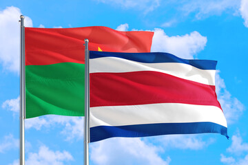 Costa Rica and Burkina Faso national flag waving in the windy deep blue sky. Diplomacy and international relations concept.