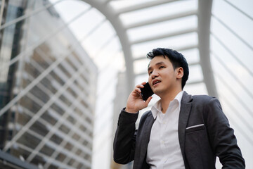 successful business man in suit talking a mobile phone in city