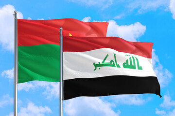 Naklejka premium Iraq and Burkina Faso national flag waving in the windy deep blue sky. Diplomacy and international relations concept.