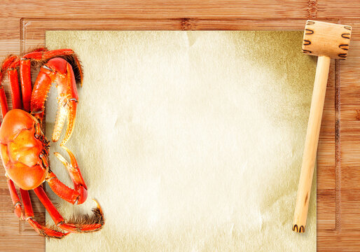 Cooked brazilian crab on a wood cutting board and paper with wooden hammer and copy space - Top view