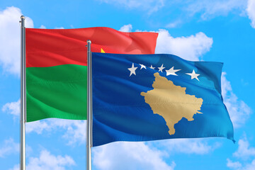 Kosovo and Burkina Faso national flag waving in the windy deep blue sky. Diplomacy and international relations concept.