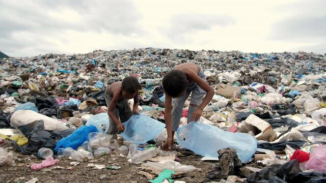Poor Kids Collects Items To Recycle On A Garbage Dump
