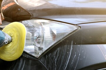 Big headlight cleaning on the car with power buffer machine at service station,Before and after...