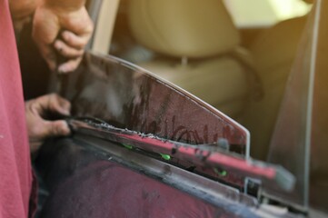 Fixing door's car engine in automobile repair garage. Mechanics in uniform are repairing car while working in auto service