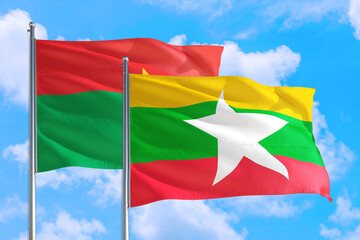 Myanmar and Burkina Faso national flag waving in the windy deep blue sky. Diplomacy and international relations concept.