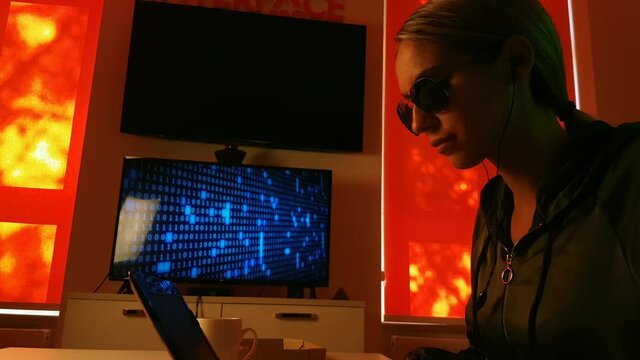 Young Female Programmer of Hacker Working Late on Laptop Computer in Dark Room. Static Close Up