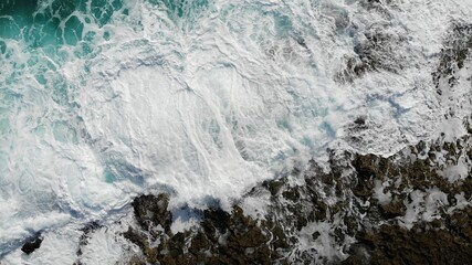 Beautiful white blue sea crashing against rocks