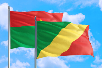 Republic Of The Congo and Burkina Faso national flag waving in the windy deep blue sky. Diplomacy and international relations concept.