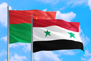 Fototapeta na wymiar Syria and Burkina Faso national flag waving in the windy deep blue sky. Diplomacy and international relations concept.