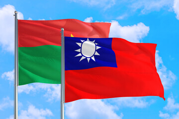 Taiwan and Burkina Faso national flag waving in the windy deep blue sky. Diplomacy and international relations concept.