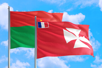 Wallis And Futuna and Burkina Faso national flag waving in the windy deep blue sky. Diplomacy and...