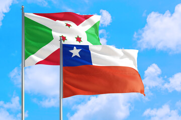 Chile and Burundi national flag waving in the windy deep blue sky. Diplomacy and international relations concept.