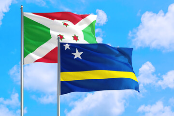 Curacao and Burundi national flag waving in the windy deep blue sky. Diplomacy and international relations concept.