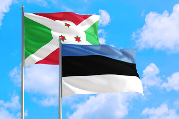 Estonia and Burundi national flag waving in the windy deep blue sky. Diplomacy and international relations concept.