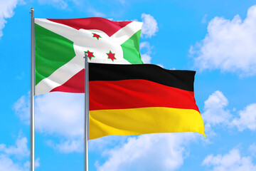 Germany and Burundi national flag waving in the windy deep blue sky. Diplomacy and international relations concept.
