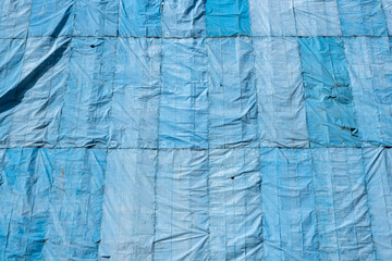 Abstract Detail Of Blue Tarpaulins With Dappled Sunlight, On A Construction Site, In Singapore. Backgrounds, Textures. Stock Photograph.