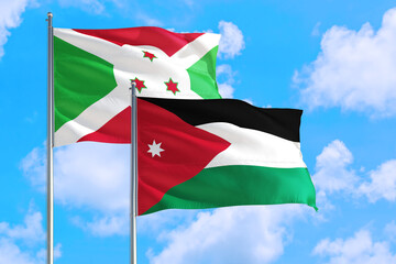 Jordan and Burundi national flag waving in the windy deep blue sky. Diplomacy and international relations concept.