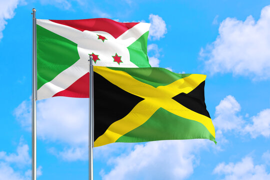 Jamaica and Burundi national flag waving in the windy deep blue sky. Diplomacy and international relations concept.