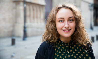 Portrait of smiling young woman standing at the street among architecture in Barcelona