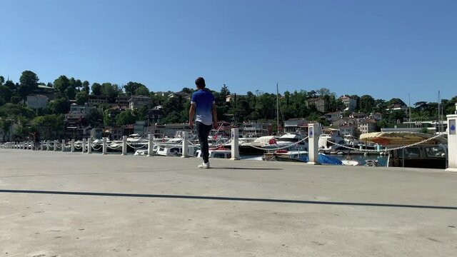 Time lapse footage of people walking, moored yachts at marina in Tarabya area of Istanbul by Bosphorus. Beautiful scene. It is a sunny summer day.