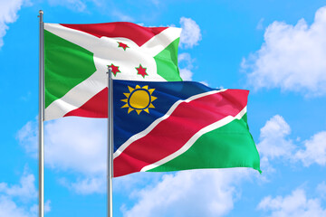 Namibia and Burundi national flag waving in the windy deep blue sky. Diplomacy and international relations concept.