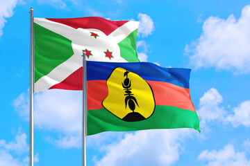 New Caledonia and Burundi national flag waving in the windy deep blue sky. Diplomacy and international relations concept.