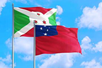 Samoa and Burundi national flag waving in the windy deep blue sky. Diplomacy and international relations concept.