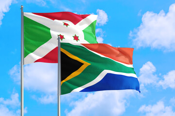 South Africa and Burundi national flag waving in the windy deep blue sky. Diplomacy and international relations concept.