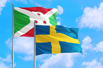 Sweden and Burundi national flag waving in the windy deep blue sky. Diplomacy and international relations concept.