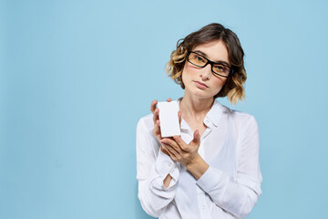 Woman wearing business card glasses in hands on blue background Copy Space cropped view