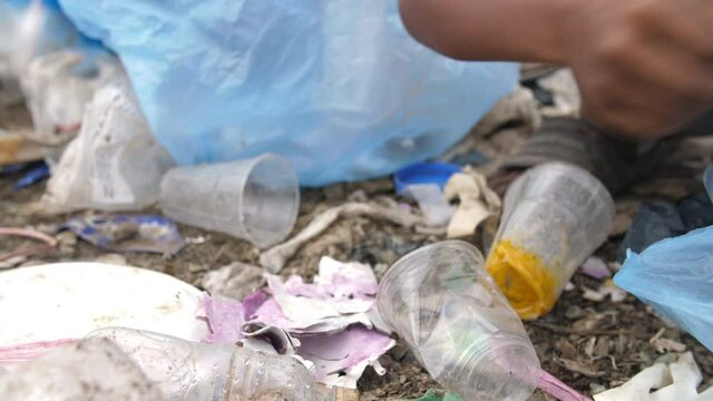 Poor Kid's Hand Collecting Trash 

