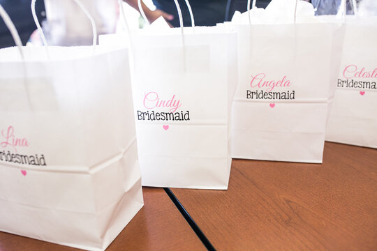 white gift bags with names of bridesmaids on them