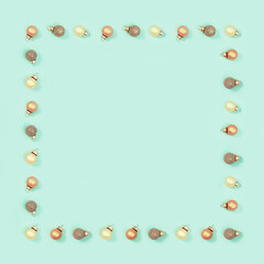 Bright shiny little Christmas balls, New Year frame on mint color background. Holiday minimal greeting card