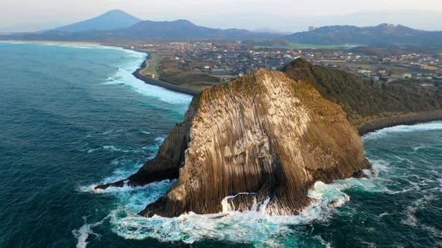 Cinematic rotating drone shot of large rock on the Kyushu coastline in Japan