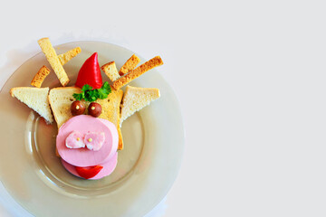 Copy space, merry christmas. Cooking a sandwich in the shape of a bull. Symbol of the new year 2021. Breakfast for children: bread, ham, pepper, tomato