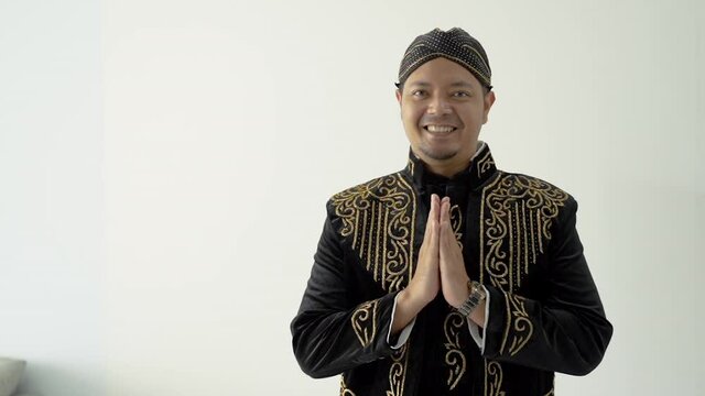 A portrait of a costume traditional Javanese man greeting gesture