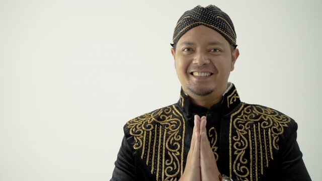 A portrait of a costume traditional Javanese man greeting gesture