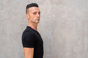 Portrait of handsome young Italian man with undercut wearing black t-shirt